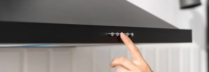 Hand betätigt Dunstabzugshaube.
